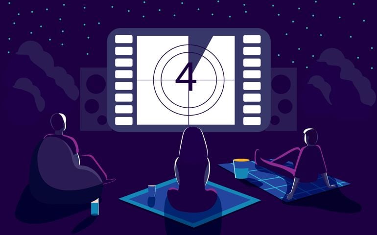 Outdoor movie theater night with friends. Watching film on big screen with sound system.