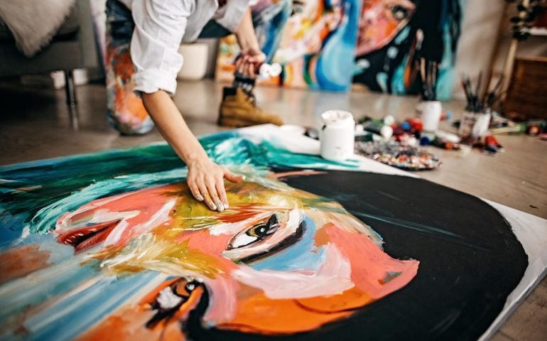 Female artist painting portrait on canvas