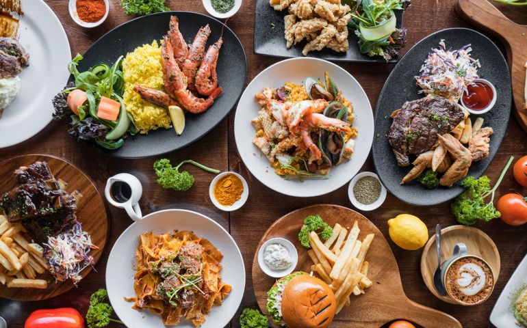 Top looking down at restaurant food spread on table.