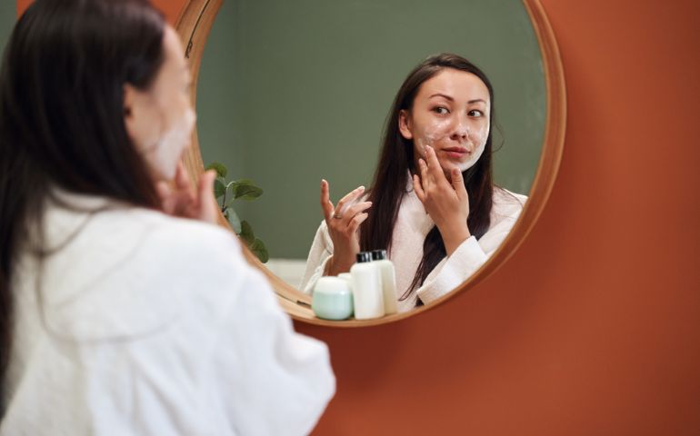 woman applying moisture cream at her face