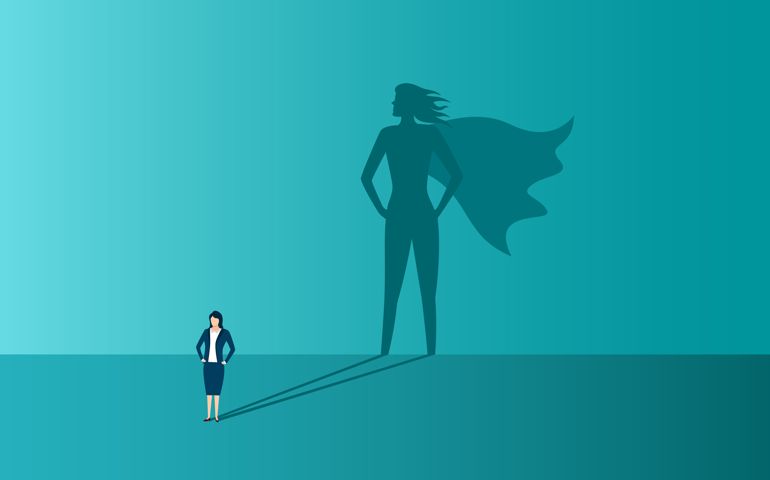Businesswoman with shadow of superhero. Concept of power,