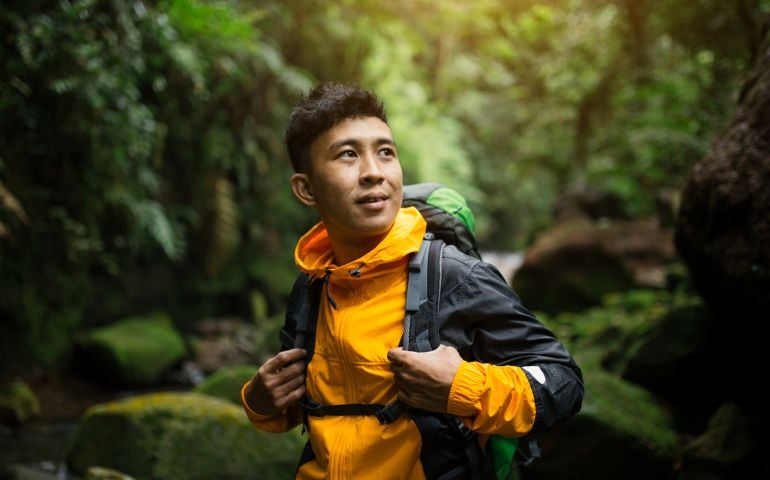 Young man in tropical mountain forest