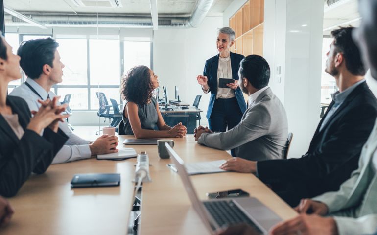 group of businesspeople sitting together and having a meeting in the office.