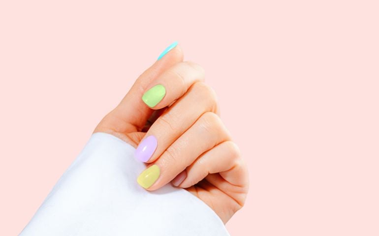 Elegant woman's hand with pastel color manicure on Easter Holiday.