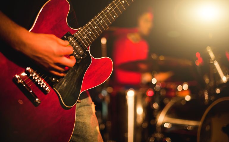 Rock guitarist playing guitar in a live show, lights and smoke