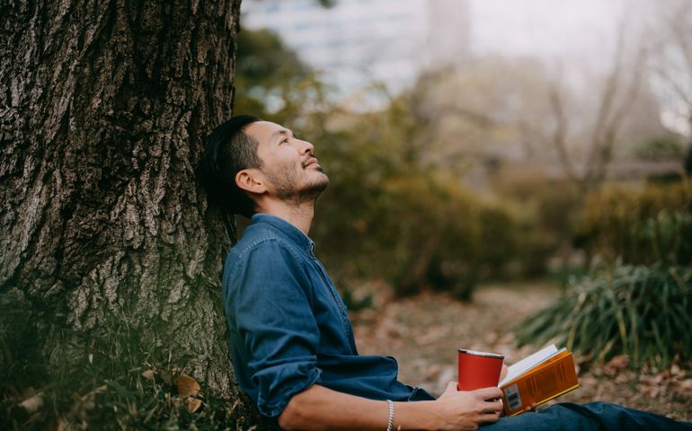 Man having a coffee break at park in city