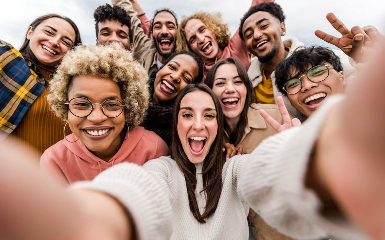 friends taking big group selfie shot smiling at camera