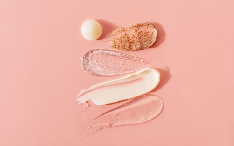 White cream for the face on pink background