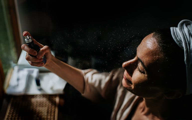 Moody, cinematic image of a woman holding a spray bottle,