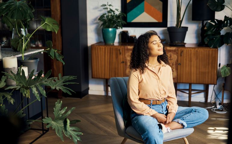 relax and happy mindset of a woman taking a mind and meditation home break. Happiness of woman on a house living room lounge chair thinking about life, gratitude and self care