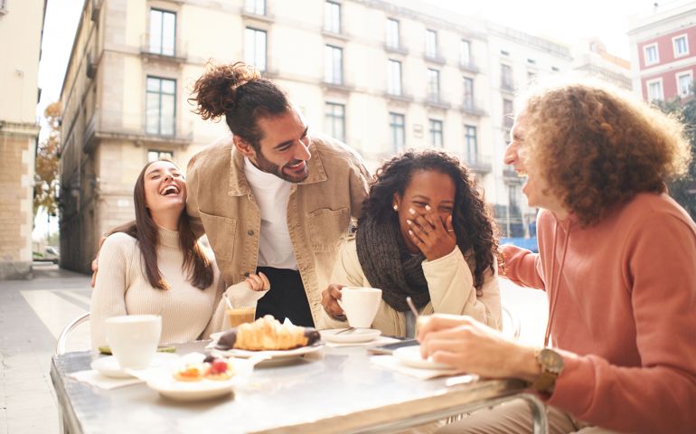 People group talking at coffee bar terrace. Friends having fun together at cafeteria on brunch time.