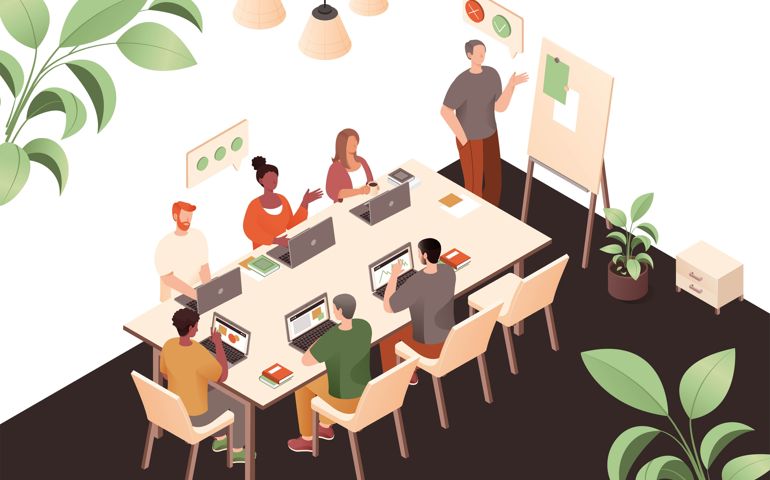 People in coworking office at table. Men and women with laptops sit at table.