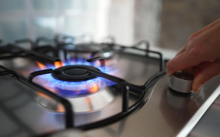 Woman turning on the gas burner off the stove.