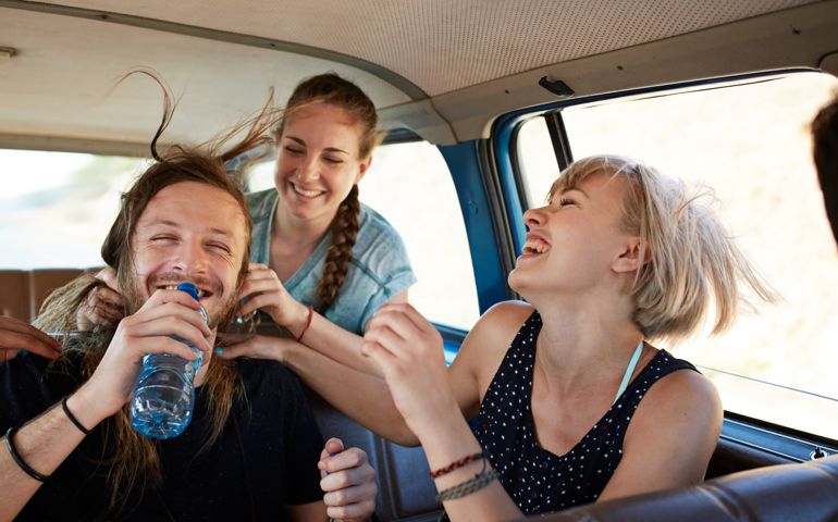 Friends laughing together inside car