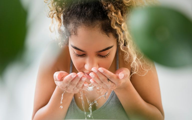 woman splashing water on face