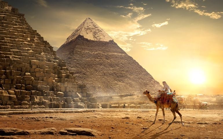 Nomad on camel near pyramids in egyptian desert