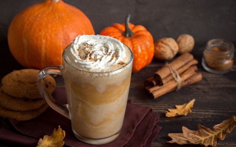 Pumpkin Spice Latte. Cup of Latte with Seasonal Autumn Spices, Cookies and Fall Decor. Traditional Coffee Drink for Autumn Holidays.