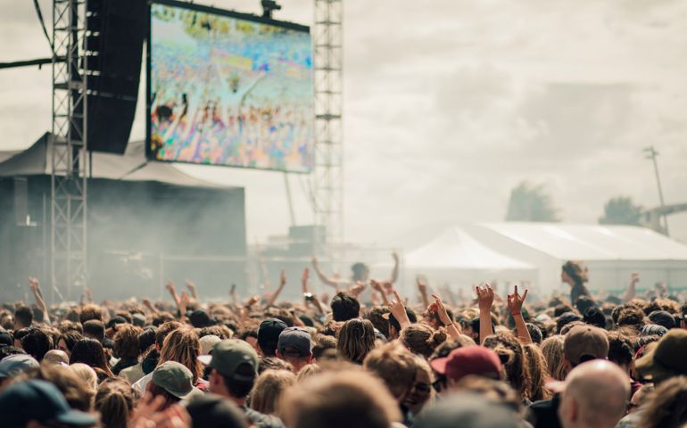 A crowd have fun at a music festival.