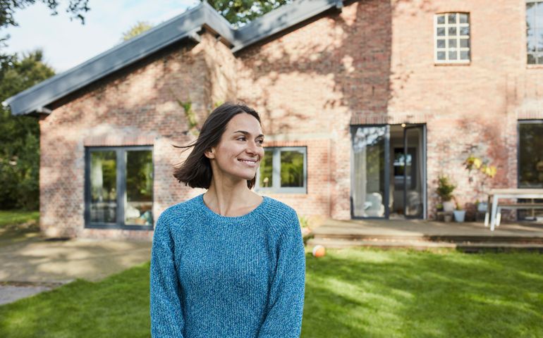 Smiling woman in garden of her home