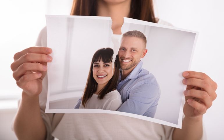 Woman Tearing Photo Of Happy Couple