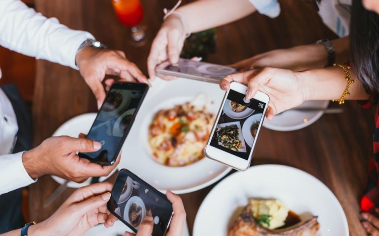 friends taking pictures of food at restaurant