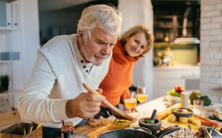 man tasting food while cooking