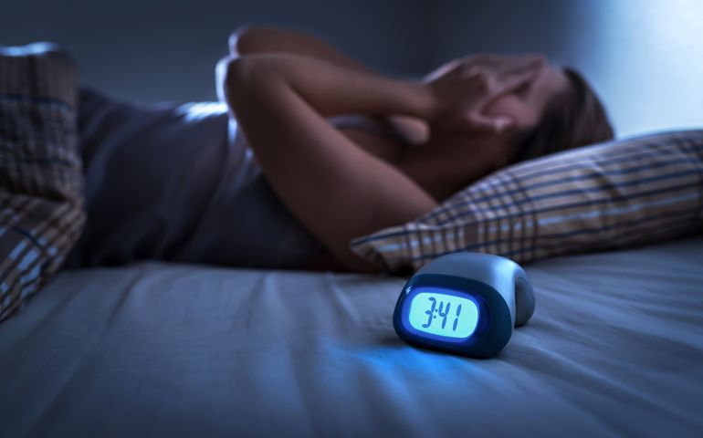 Sleepless woman suffering from insomnia, sleep apnea or stress. Tired and exhausted lady. Headache or migraine. Awake in the middle of the night. Frustrated person with problem.
