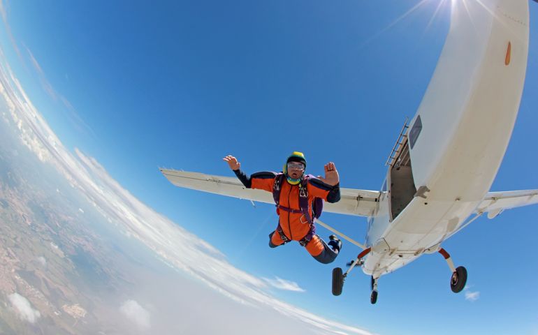 man parachutist jumping off an airplane.