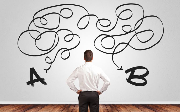 Businessman looking for solution while standing in front of a wall