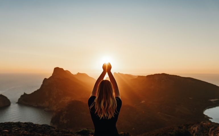Young woman in spiritual pose holding the light