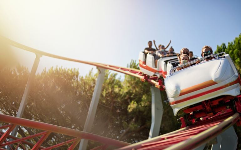Kids having fun in amusement park roller coaster