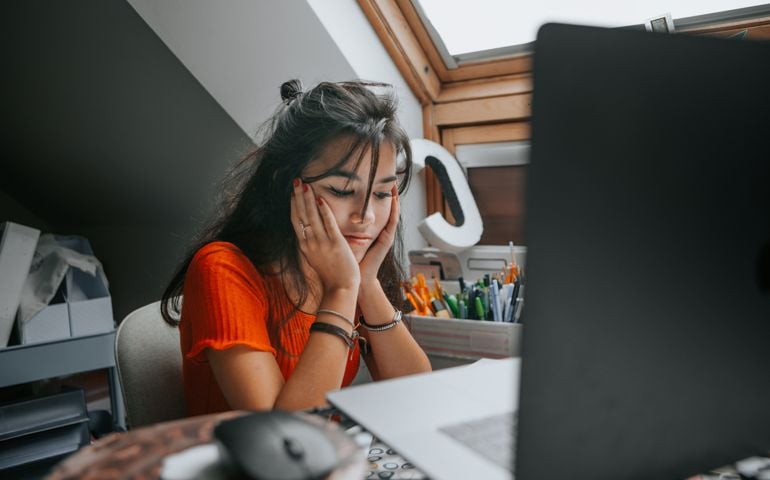 female teenager feeling stressed studing at home.