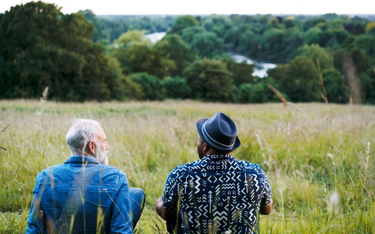 Two men sat, talking, looking at view