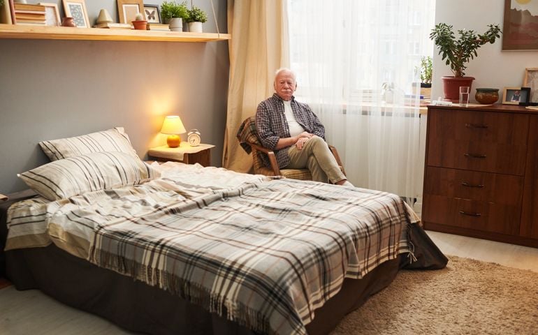 Senior man sitting in his bedroom
