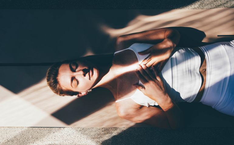 woman trainer in white sportswear practices yoga exercise