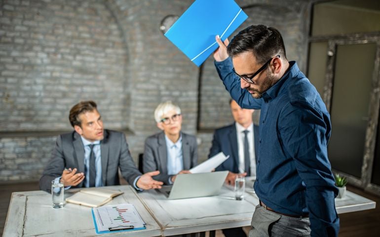 Frustrated male candidate leaving a job interview after a rejection.