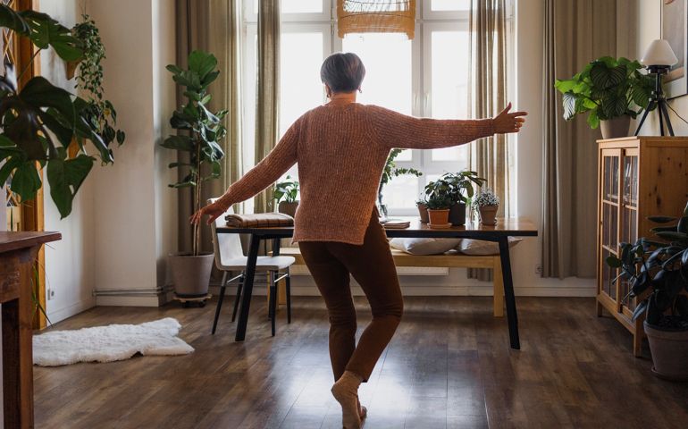 senior woman dancing in living room at home