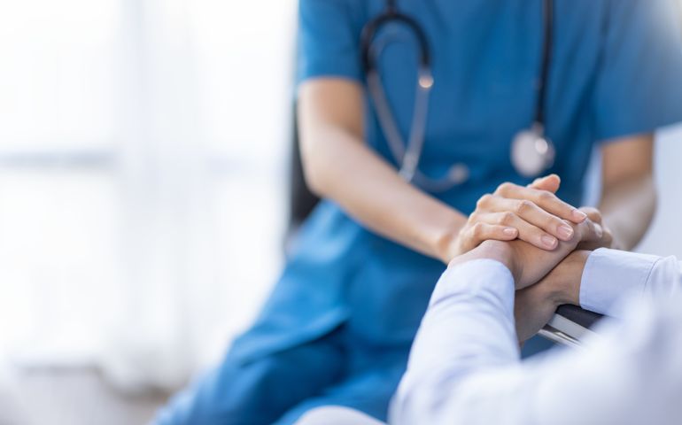 Cropped shot of a female nurse hold her senior patient's hand. Giving Support. Doctor helping old patient with Alzheimer's disease. Female carer holding hands of senior man