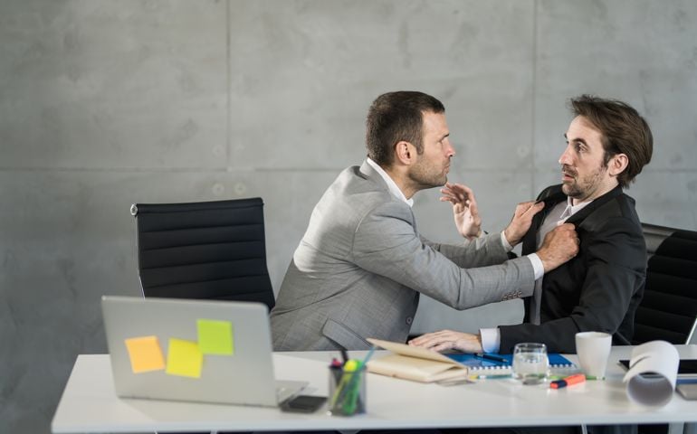 Angry businessman attacking his employee in the office.