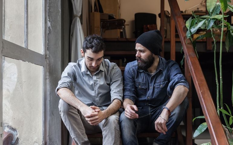 Couple of young men talking on the stairs