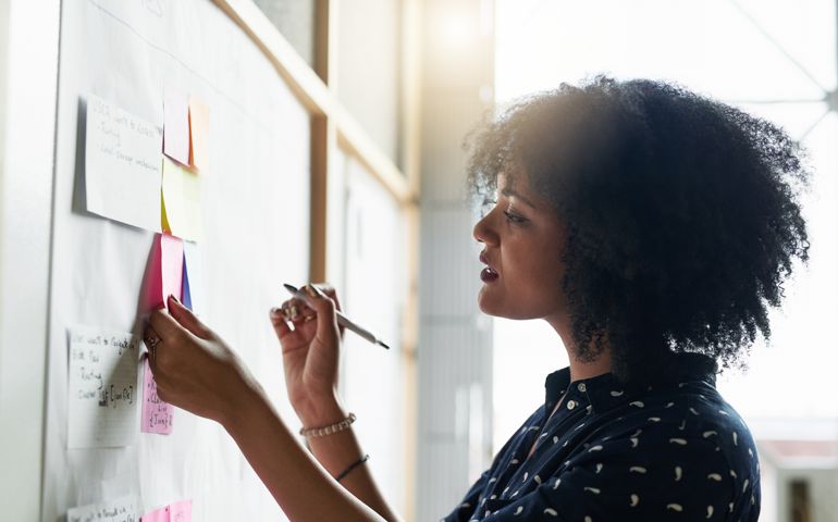 woman writing down on post it notes