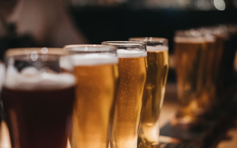 Close up of a rack of different kinds of beers, dark to light, on a table.