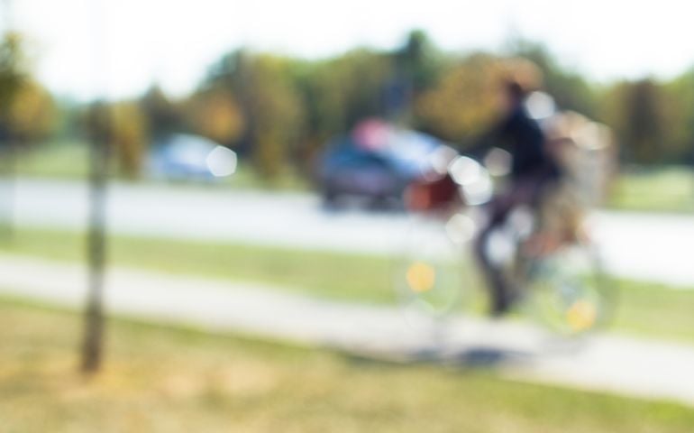 Defocused man ride bike on the city street