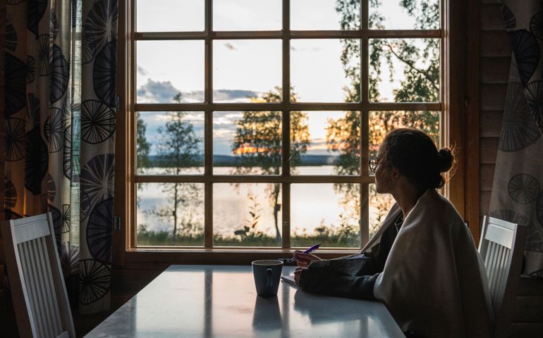 woman looking outside of window at dusk