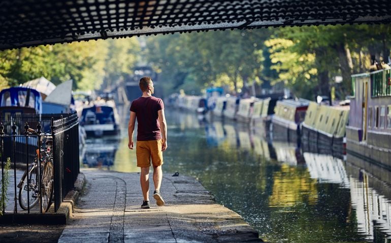 man walking by canal