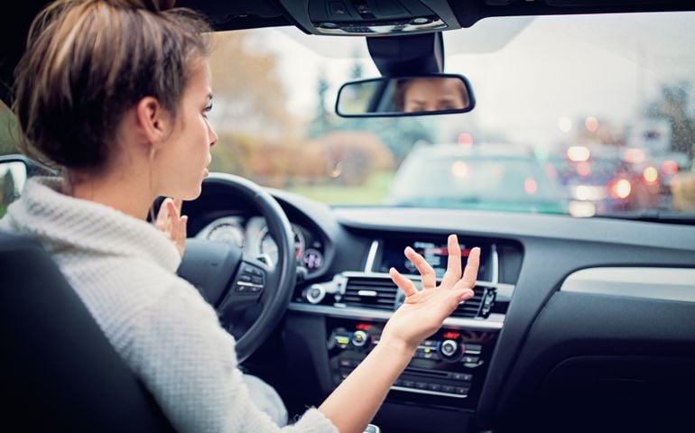 Frustrated young girl is waiting in the traffic jam in a rainy day