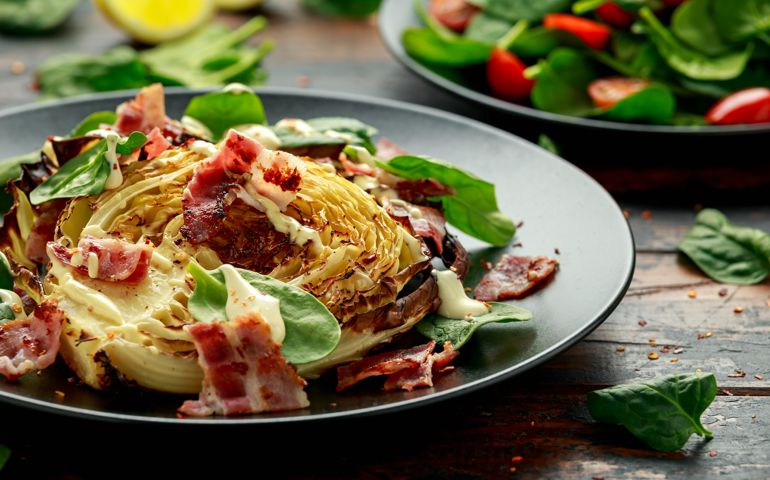 Oven roasted cabbage steaks with bacon, spinach and mayonnaise. healthy food
