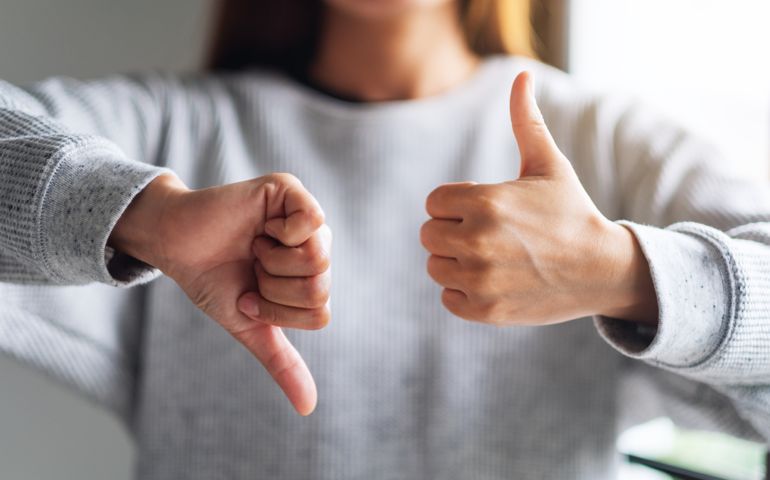 a woman making thumbs up and thumbs down hands sign