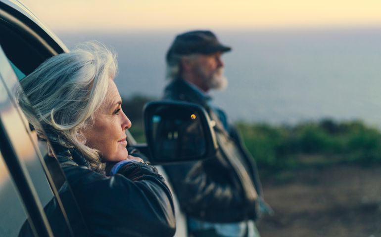 Mature woman sitting in car during sunset