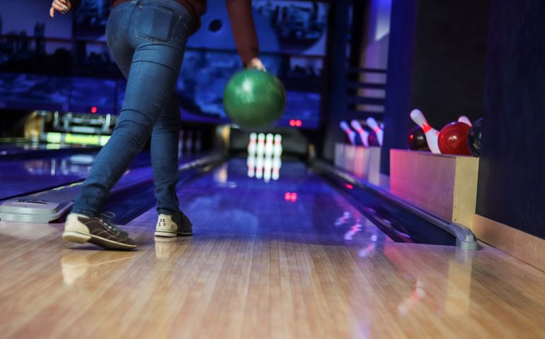Woman in club for bowling is throwing ball